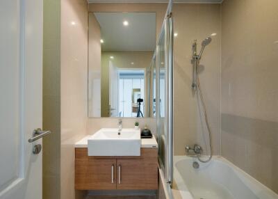 Modern bathroom with sink, mirror, and bathtub with shower