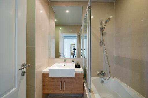 Modern bathroom with sink, mirror, and bathtub with shower