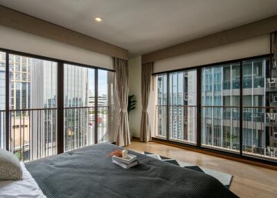 Spacious bedroom with large windows and a city view