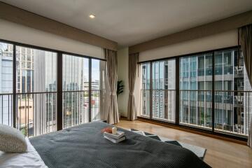 Spacious bedroom with large windows and a city view