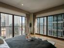 Spacious bedroom with large windows and a city view