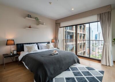 Modern bedroom with a large window and a city view