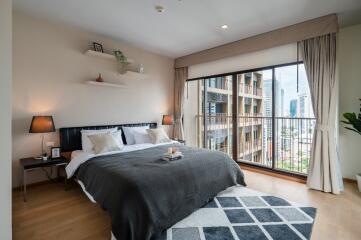 Modern bedroom with a large window and a city view