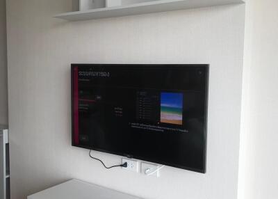 Living room with wall-mounted TV and shelves