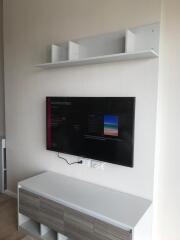 Living room with wall-mounted TV and shelves