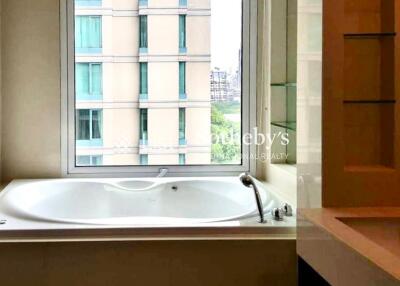 Modern bathroom with large bathtub and view of neighboring building