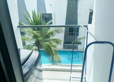 Balcony with view of pool and surrounding buildings