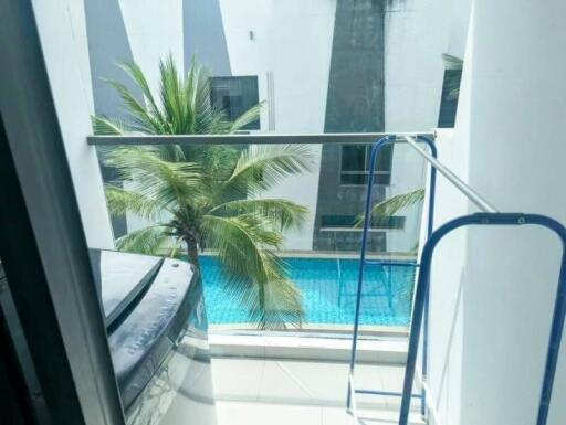 Balcony with view of pool and surrounding buildings