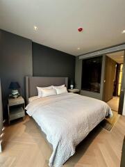 Modern bedroom with double bed, bedside tables, and soft lighting.