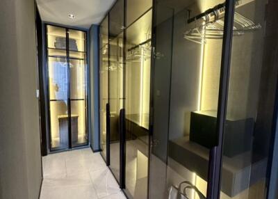 Modern walk-in closet with glass doors and ample storage