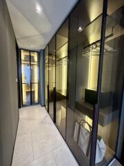 Modern walk-in closet with glass doors and ample storage