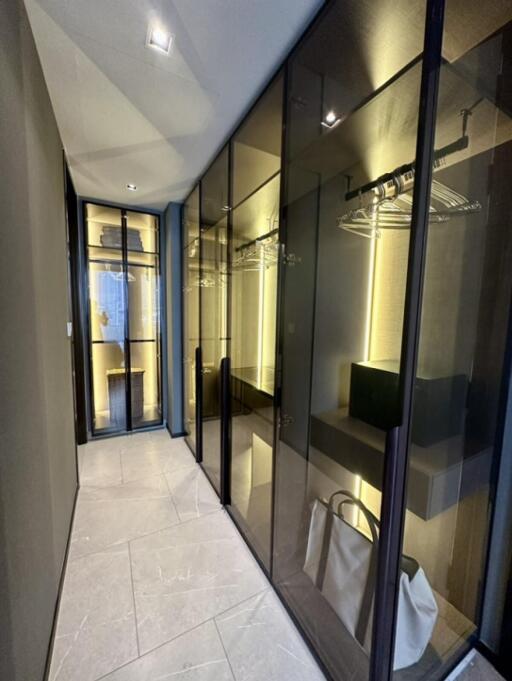 Modern walk-in closet with glass doors and ample storage