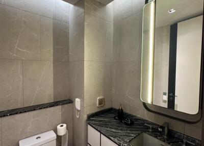 Modern bathroom with illuminated mirror and marble countertop