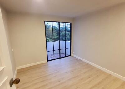 Bedroom with large window and hardwood floors