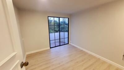 Bedroom with large window and hardwood floors