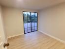 Bedroom with large window and hardwood floors