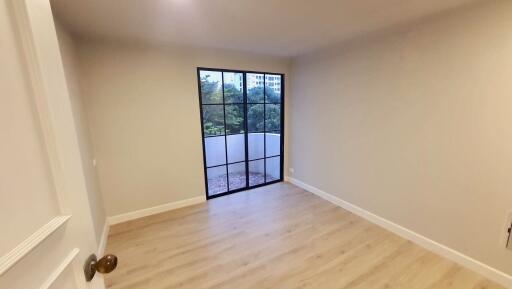 Bedroom with large window and hardwood floors