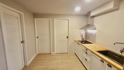 Modern kitchen with wooden countertops and white cabinets