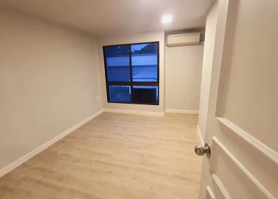 Empty bedroom with window and air conditioning unit