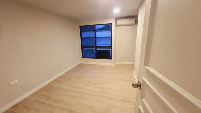 Empty bedroom with window and air conditioning unit