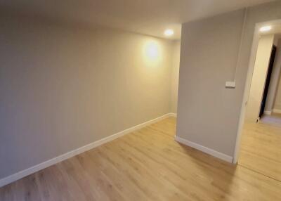 Small bedroom with wooden flooring and recessed lighting