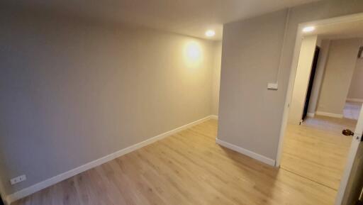 Small bedroom with wooden flooring and recessed lighting