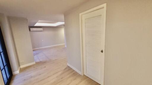 Modern living space with wooden flooring and a closet door