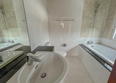 Modern bathroom with sink, bathtub, and tiled walls