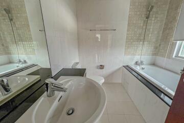 Modern bathroom with sink, bathtub, and tiled walls