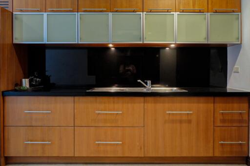 Modern kitchen with wooden cabinets and black countertops