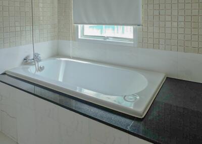 Modern bathroom with a bathtub and tiled walls