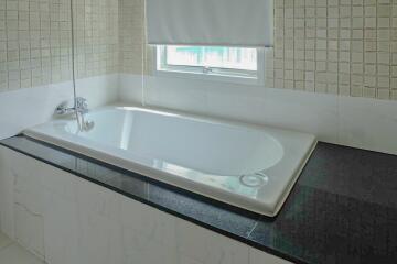 Modern bathroom with a bathtub and tiled walls