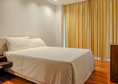 Cozy bedroom with white bedding and yellow curtains