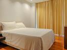 Cozy bedroom with white bedding and yellow curtains