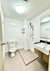 Modern bathroom with toilet, sink, and shower