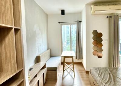 Modern bedroom with wooden furniture, large window, and natural light