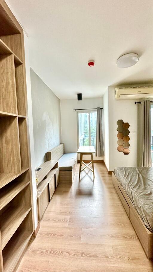 Modern bedroom with wooden furniture, large window, and natural light