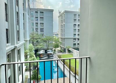 View from balcony overlooking building courtyard with swimming pool