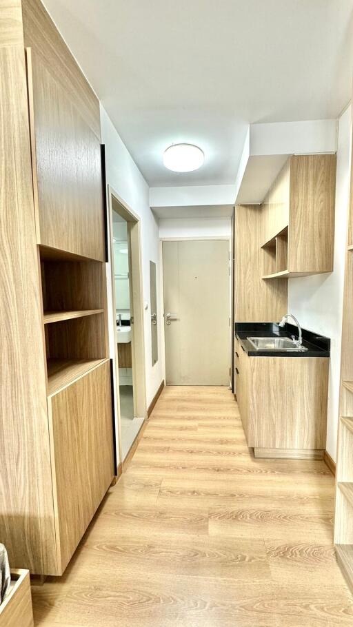 Compact modern kitchen with wooden cabinets and black countertop