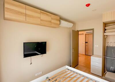 Modern bedroom with wooden cabinets and wall-mounted TV