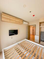 Modern bedroom with wooden cabinets and wall-mounted TV