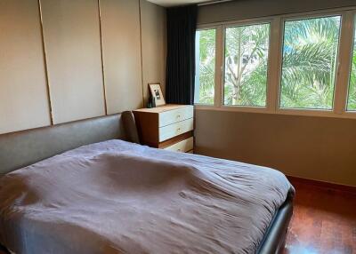 Cozy bedroom with large windows and greenery view