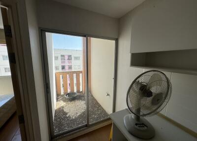 Small balcony view from an interior room with a fan