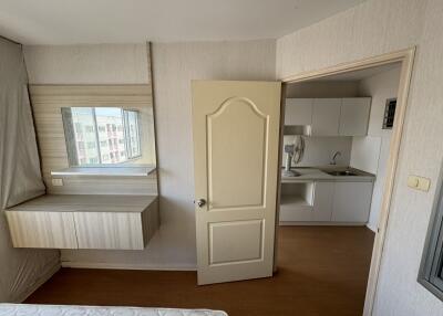 Small bedroom with view into kitchenette