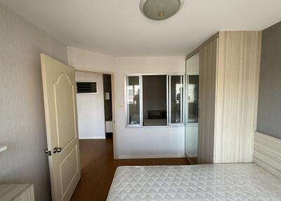 Bedroom with white door, glass window, and wooden furniture