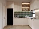 Modern kitchen with black fridge and green backsplash