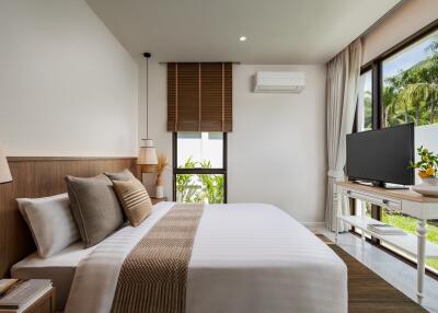 Modern bedroom with a large bed, wall-mounted air conditioning, and window view