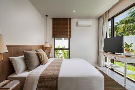 Modern bedroom with a large bed, wall-mounted air conditioning, and window view