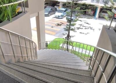 Curved stairway with railing leading to an outdoor area