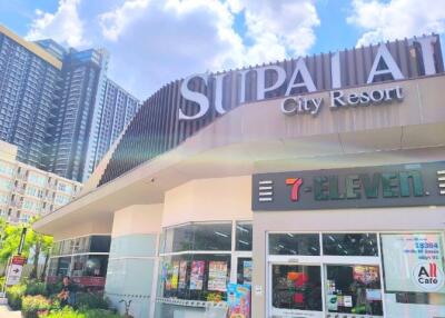 Exterior view of Supalai City Resort with a 7-Eleven store